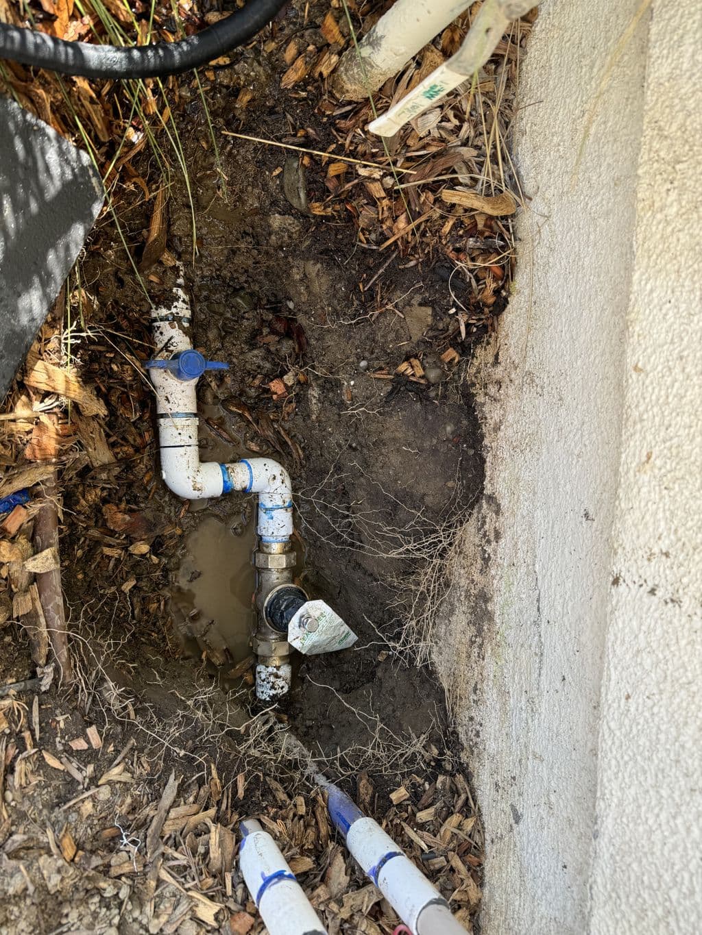 Excavated irrigation piping with ball valve and brass fitting. Work by Construction Hub in Los Angeles.