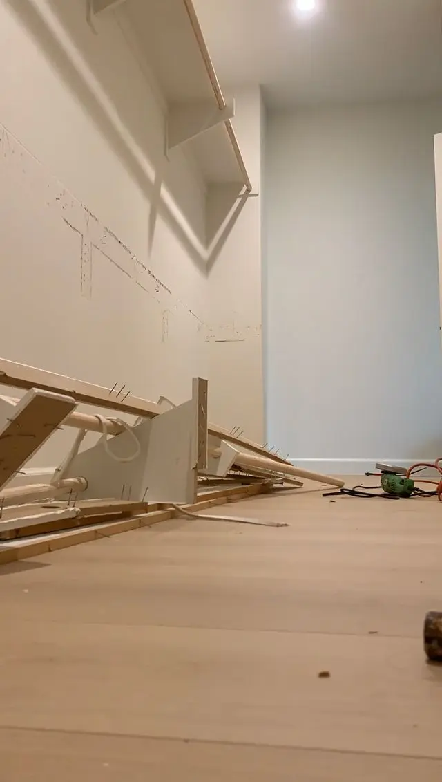 Room cleared for repair with dismantled furniture stacked against a bare wall. Work by Construction Hub in Los Angeles.