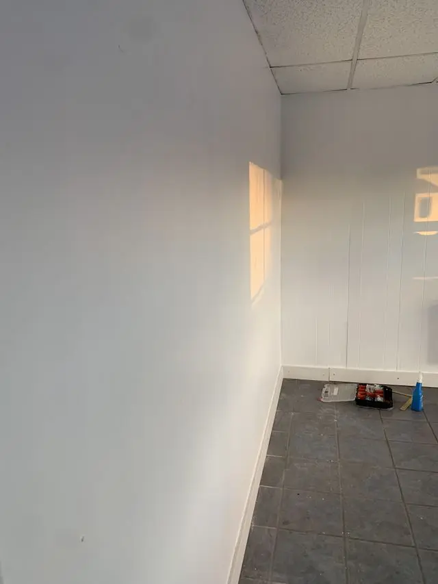 Narrow room painted white with a tool bag left on the tiled floor. Work by Construction Hub in Los Angeles.