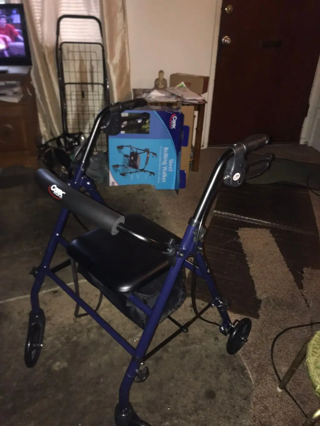 Assembled blue steel rolling walker beside its packaging box. Work by Construction Hub in Los Angeles.