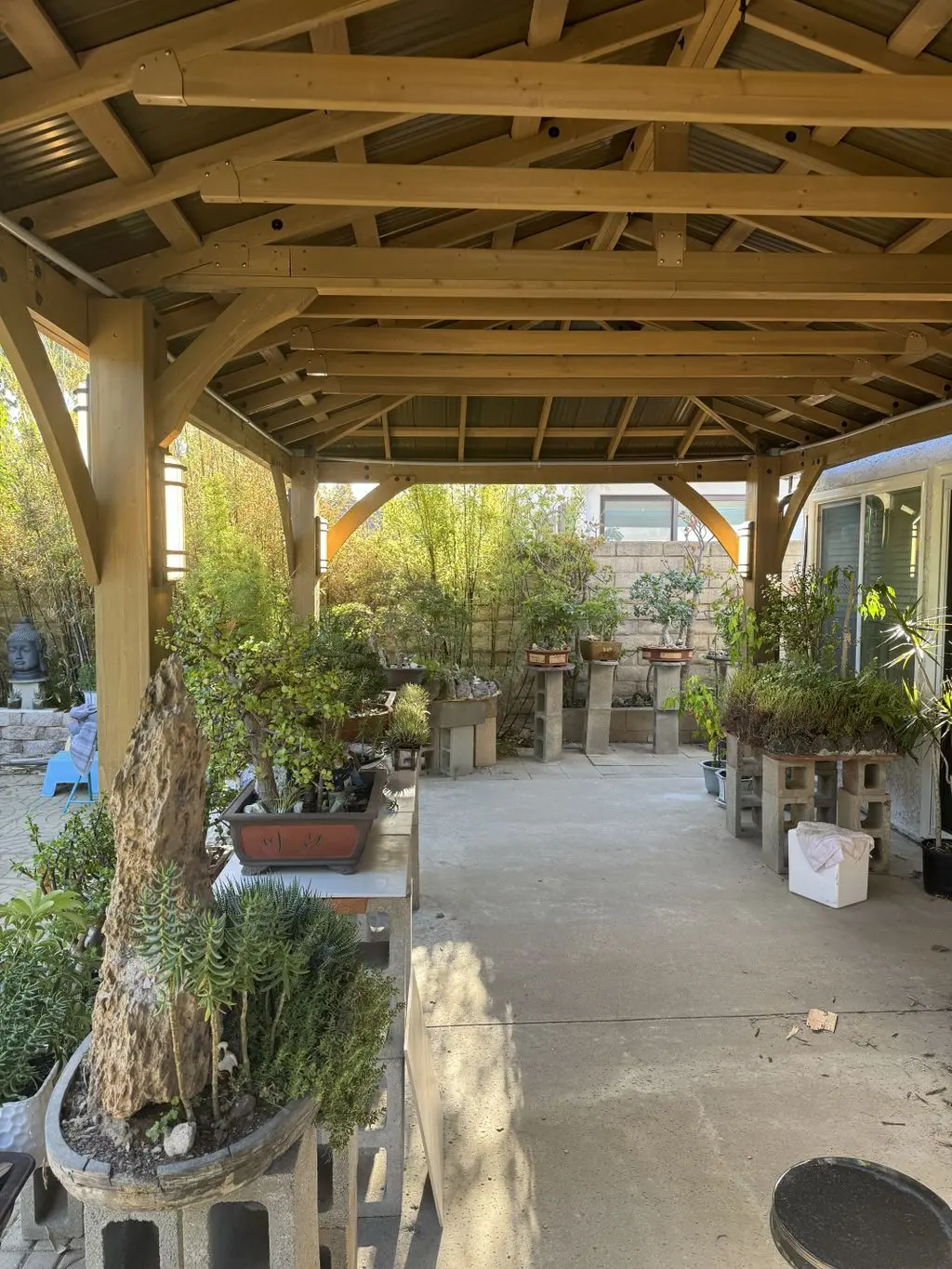 Interior of cedar pavilion with sconce lights over patio. Work by Construction Hub in Los Angeles.