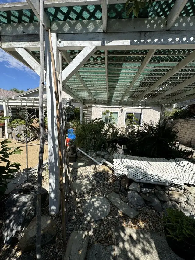 Patio cover framing with lattice above a rock garden, part way through the build. Work by Construction Hub in Los Angeles.