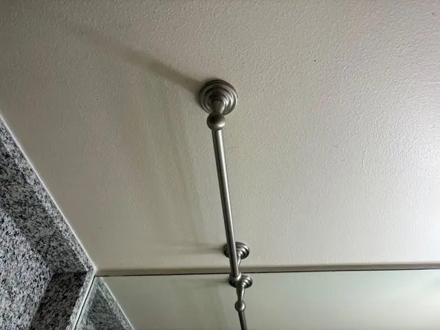 Brushed nickel rod anchored to ceiling above mirrored wall. Work by Construction Hub in Los Angeles.
