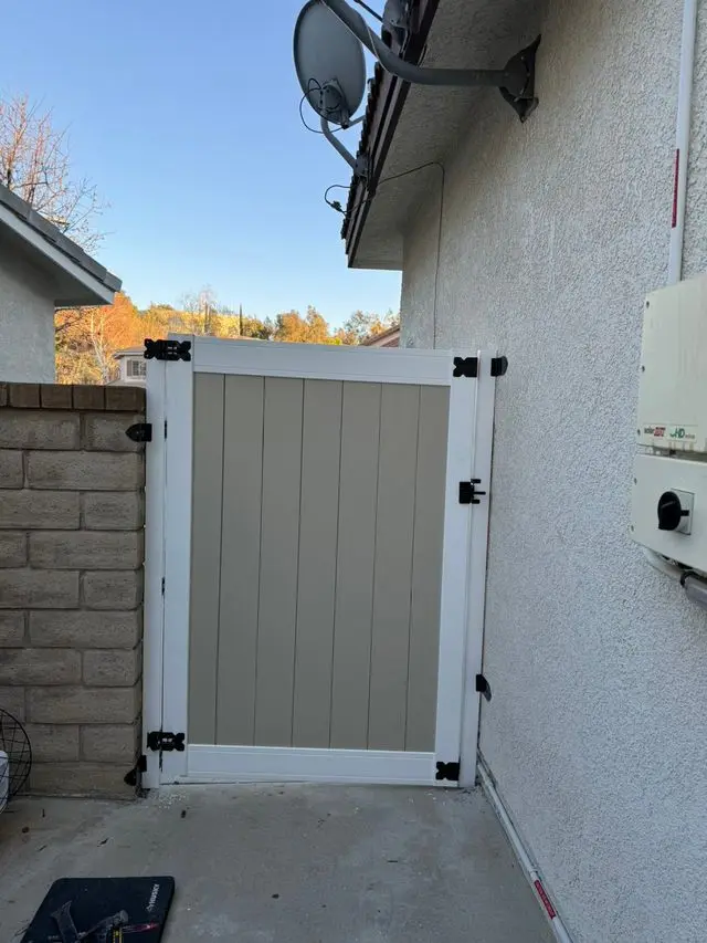 New white vinyl side gate installed beside stucco wall. Work by Construction Hub in Los Angeles.