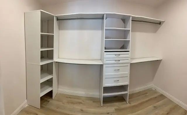 Curved corner closet unit with a drawer tower and open shelving. Work by Construction Hub in Los Angeles.