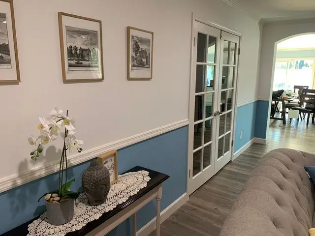 Hallway painted white above and blue below a chair rail. Work by Construction Hub in Los Angeles.