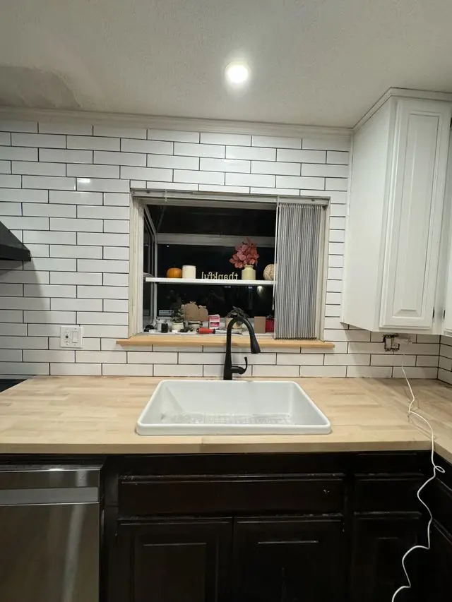 Subway tile backsplash behind new sink and butcher block counter. Work by Construction Hub in Los Angeles.
