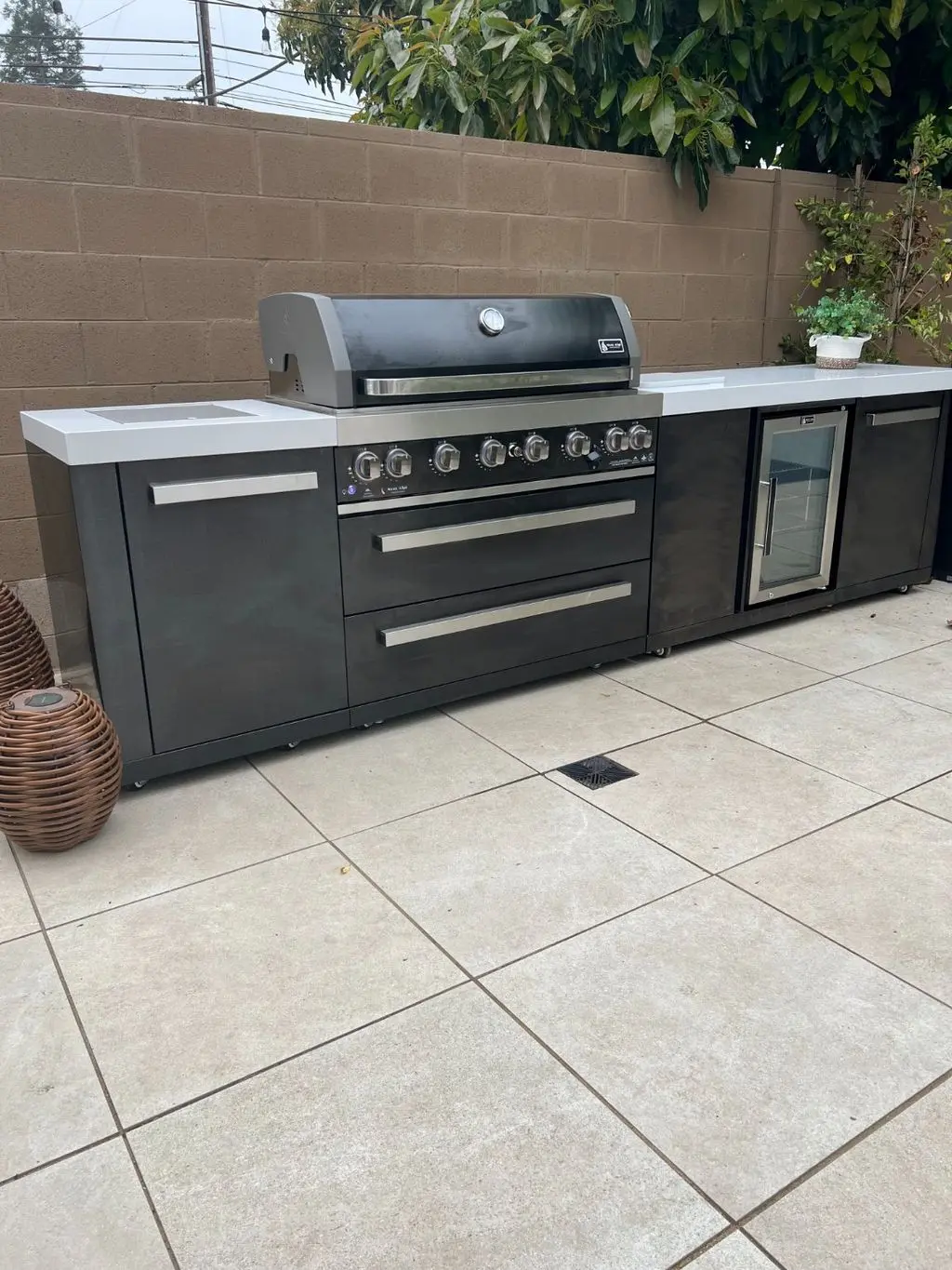 Outdoor kitchen island with grill, drawers and beverage fridge. Work by Construction Hub in Los Angeles.