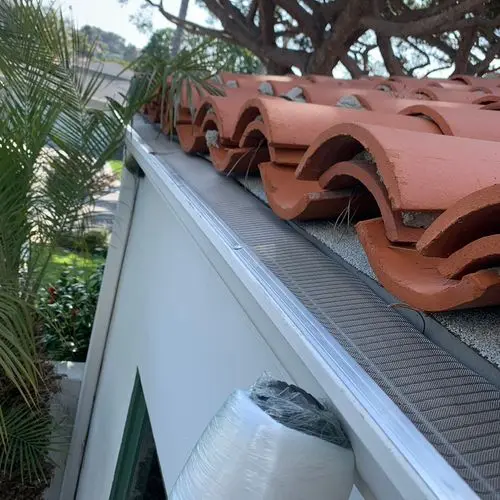 Mesh gutter guard installed along clay tile roof edge. Work by Construction Hub in Los Angeles.