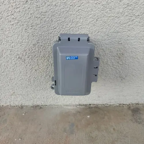 Weatherproof in-use cover over GFCI outlet on stucco wall. Work by Construction Hub in Los Angeles.