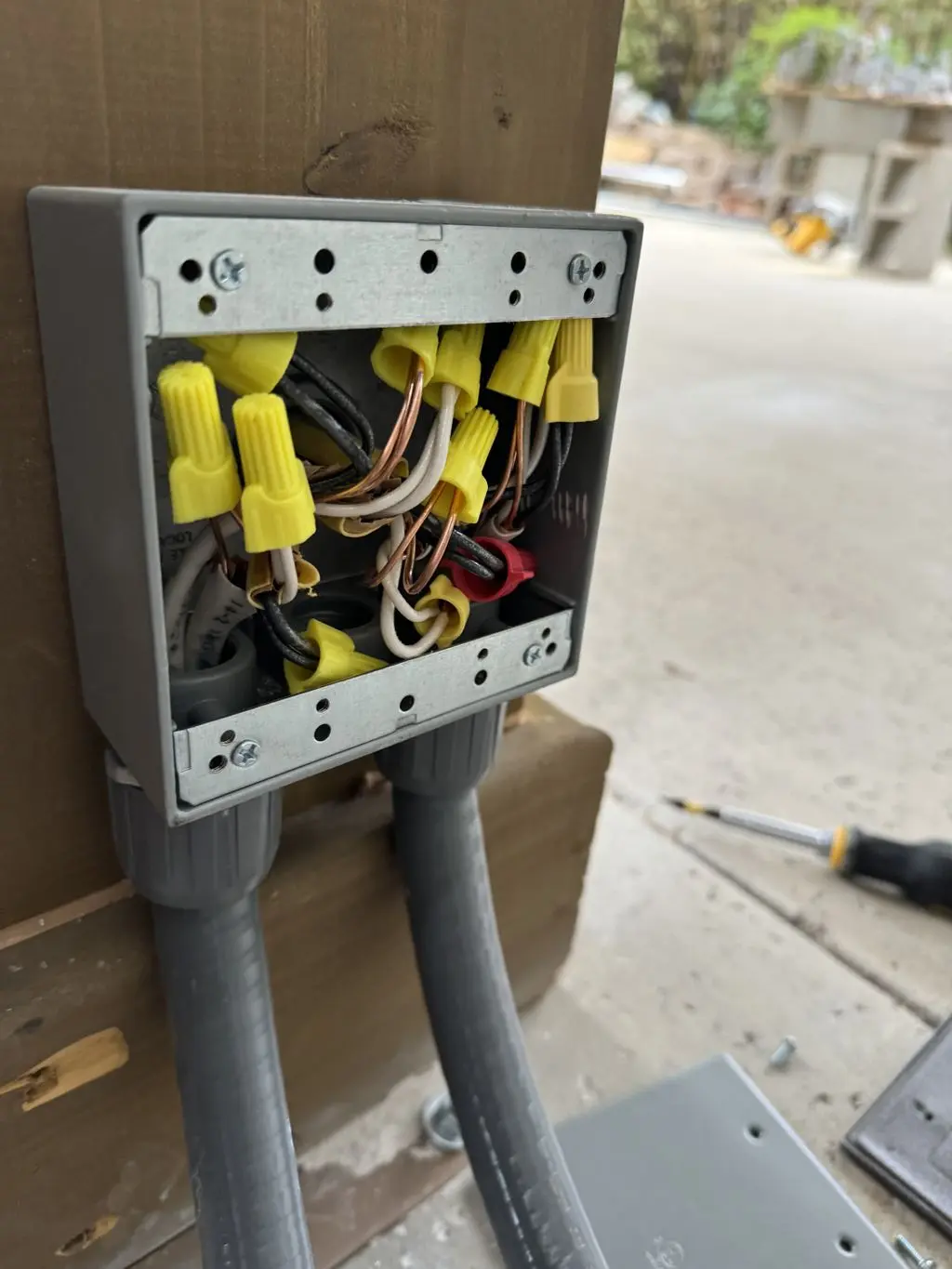 Open outdoor junction box wired with wire nuts and conduit. Work by Construction Hub in Los Angeles.