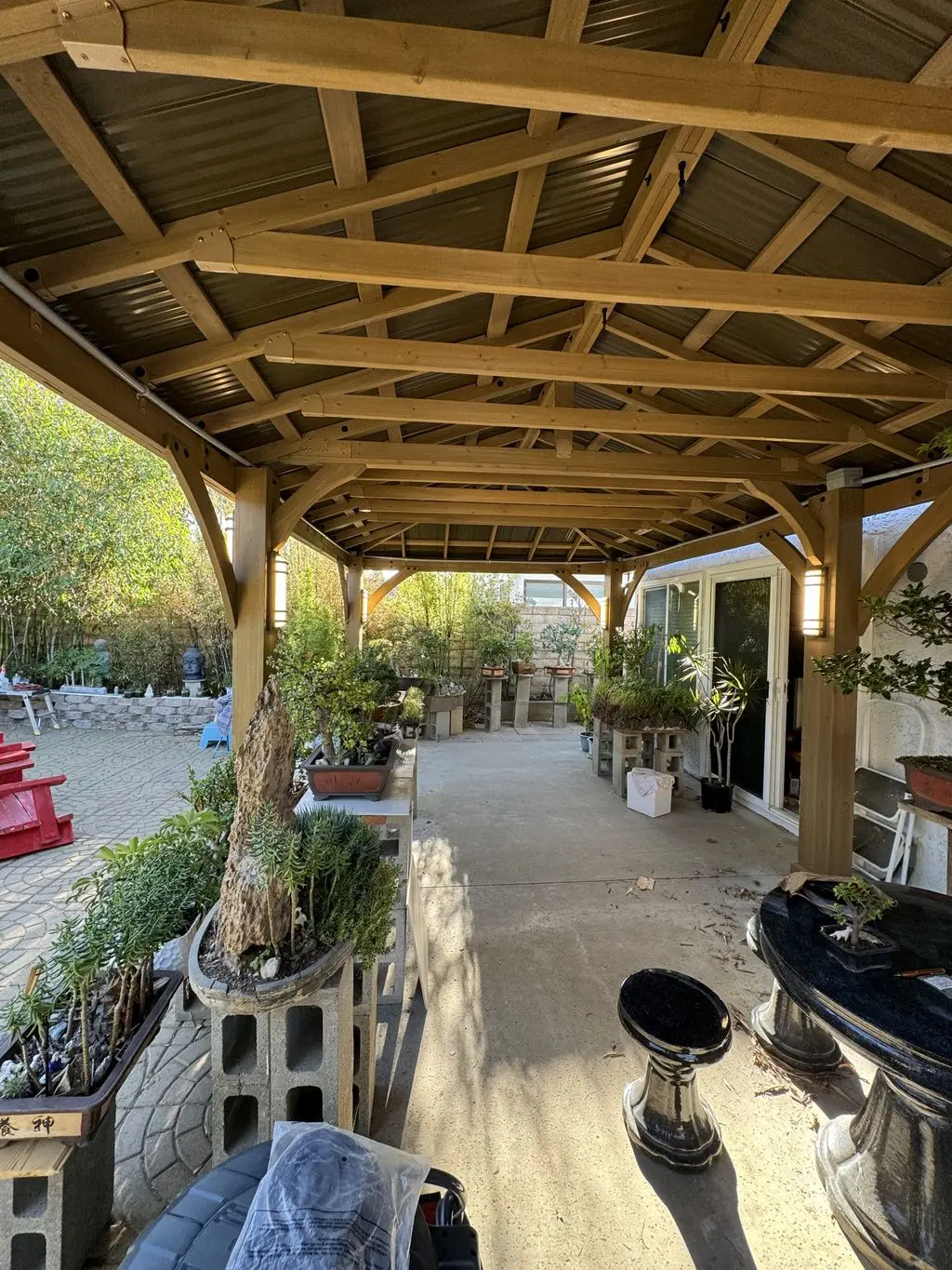 Finished cedar pavilion with metal roof over backyard patio. Work by Construction Hub in Los Angeles.