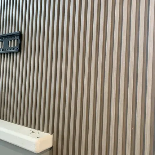 Black TV wall bracket fixed to a new wood slat panel wall. Work by Construction Hub in Los Angeles.