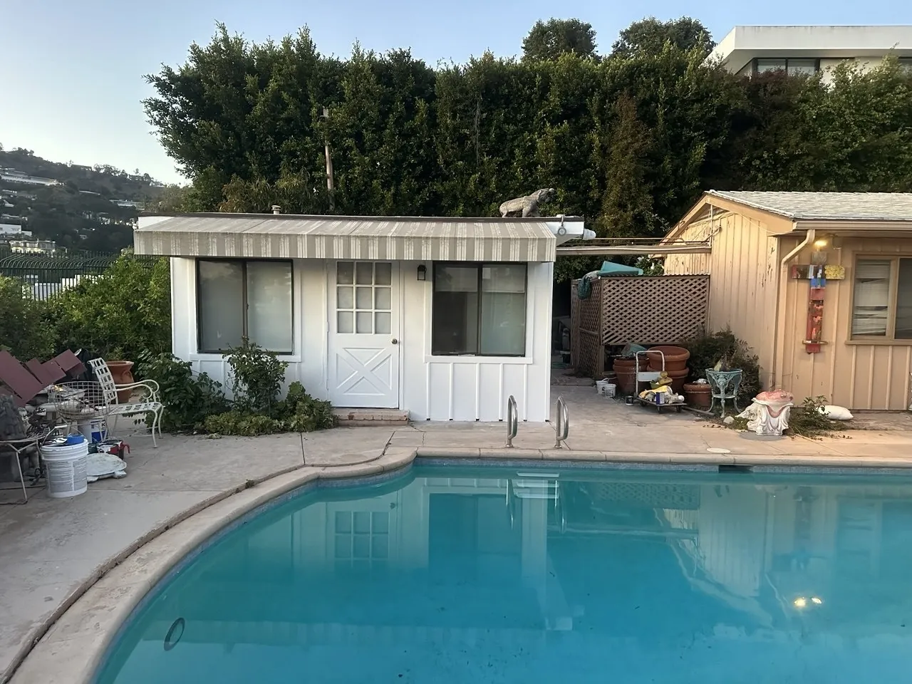 Pool house repainted white next to a swimming pool