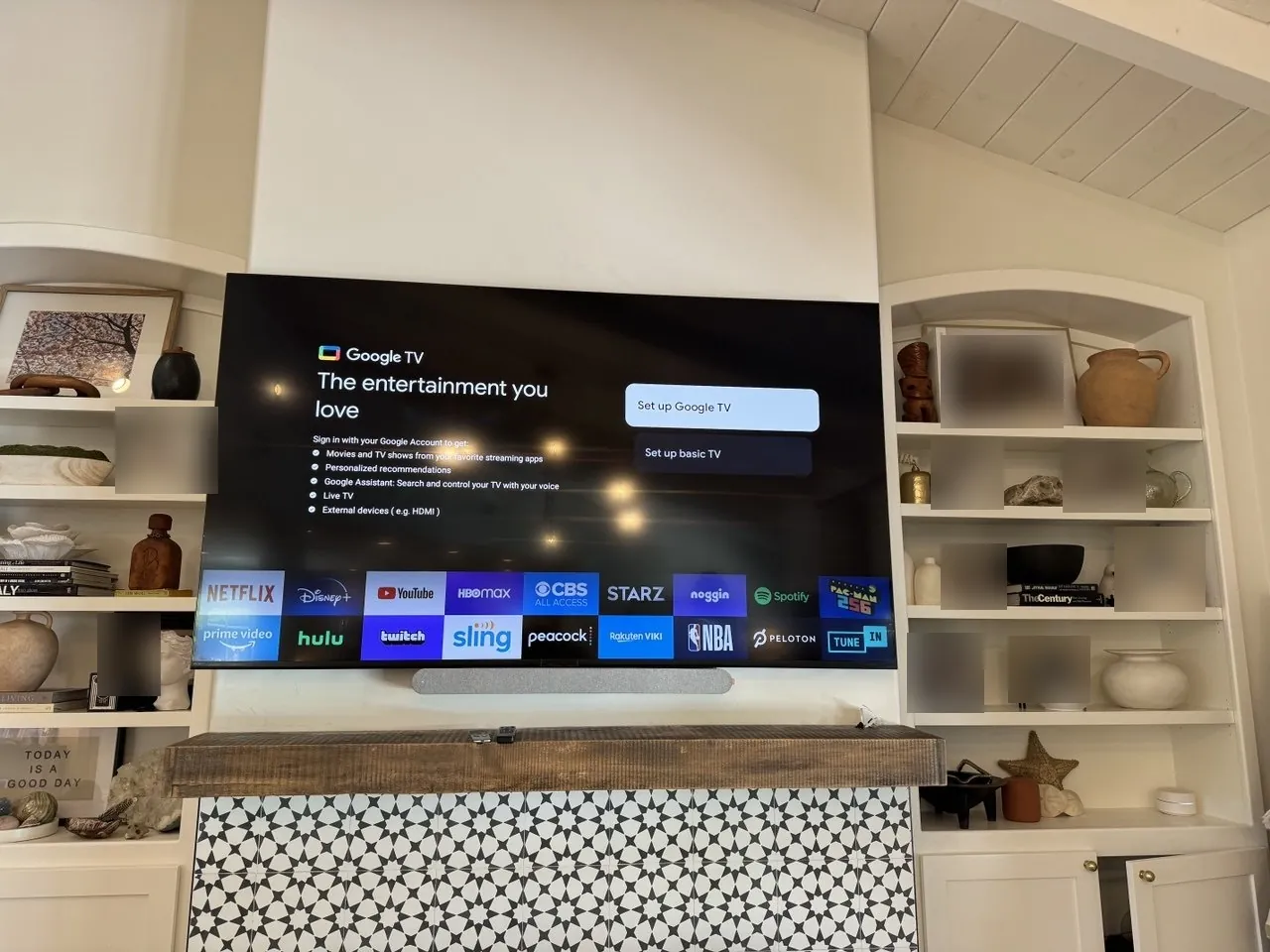 Wall-mounted TV above a fireplace between built-in bookshelves. Work by Construction Hub in Los Angeles.