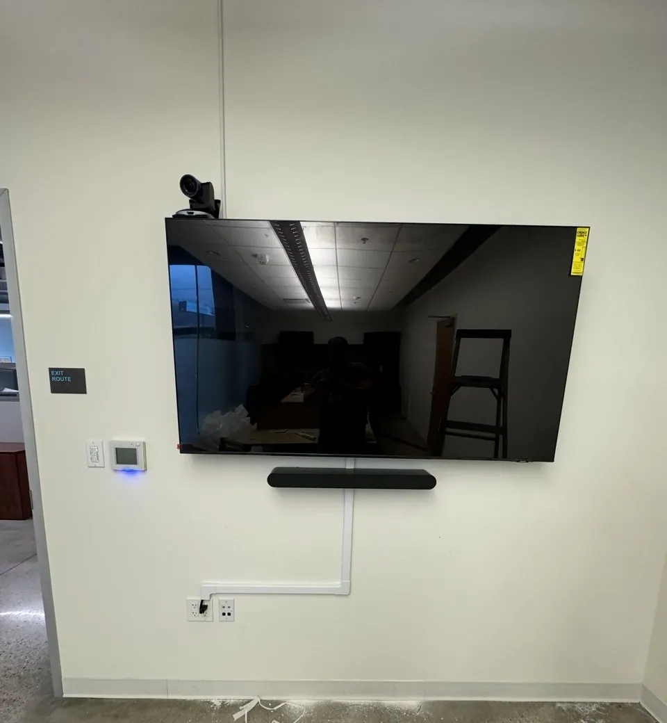 Wall-mounted TV with soundbar and conduit-hidden wiring