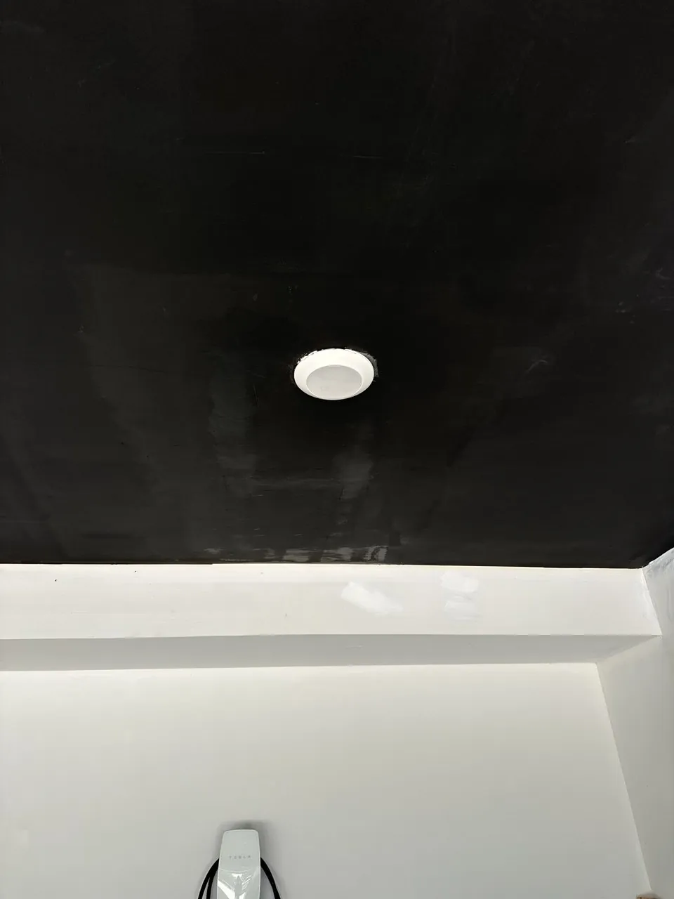 Repaired and repainted ceiling around a light fixture with the patch no longer visible