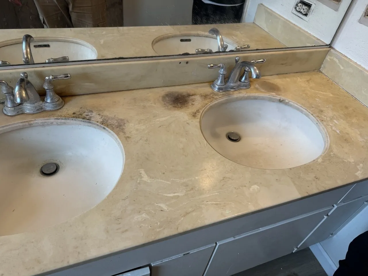 Stained yellow double-sink vanity countertop before refinishing